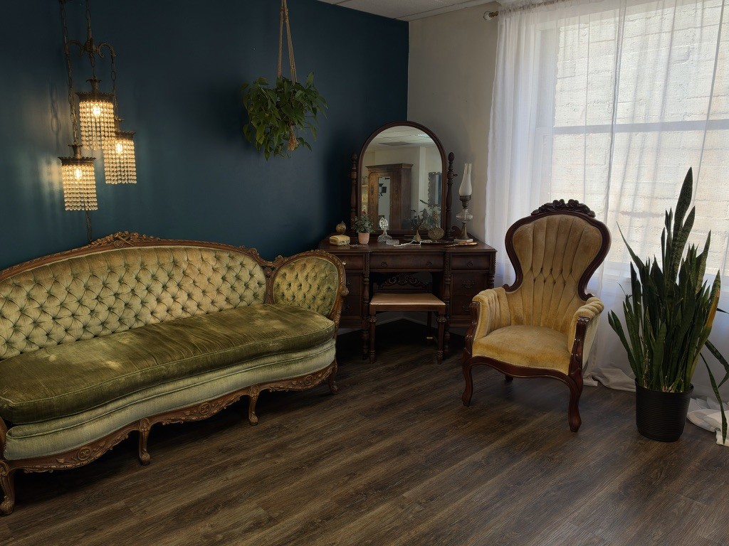 Private boudoir studio at TiffaneyAnn Photography in Downtown Long Beach with a green velvet sofa, vintage vanity and crystal pendant lights